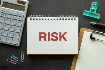 There is notebook with the word RISK. It is an abbreviation for RISK as eye-catching image.