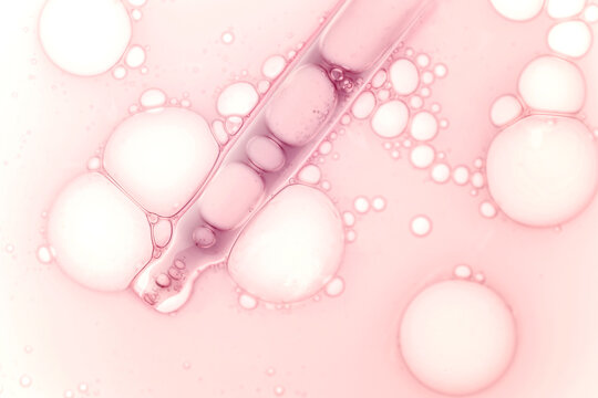 Liquid pink red ampoule gel or serum on white isolated background. Cosmetic beauty product texture sample swatch