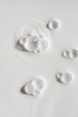 Cosmetic cream milk body lotion foam texture milky blue colored background