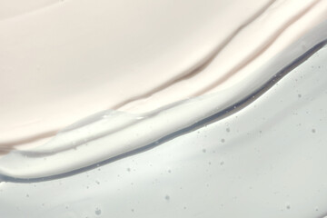 Cosmetic beauty product texture sample swatch. Two products mix. Blue gel serum or peeling and milky white cream balm.