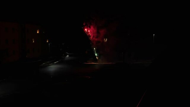 Pyrotechnic show.People set off fireworks on a dark city street.Christmas and New Year pyrotechnic light show. 4k footage