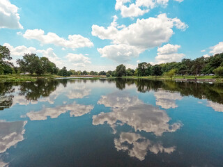 Beautiful Summer lake scene at Forest Park in St. Louis, Missouri, USA. Clouds and trees reflect upon the water. City park located in the heart of the city.