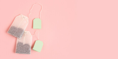 Tea bags  on pink background with space for text, top view