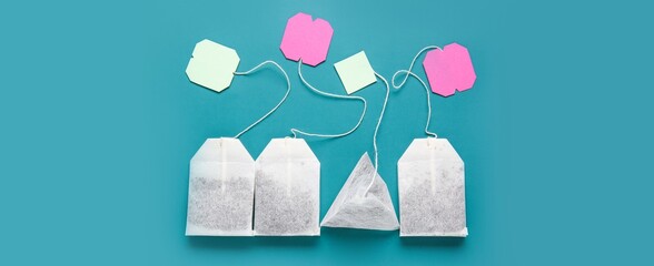 Tea bags on blue background, top view
