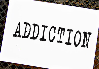 ADDICTION - word on white sheet on black grid background
