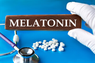 Cubes with the word MELATONIN in the hand of a doctor.