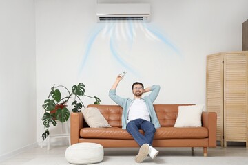 Man switching on air conditioner in living room