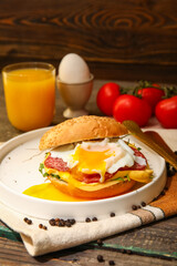 Plate with tasty egg Benedict on wooden background