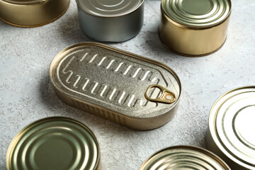 Tin cans with fish on grey table