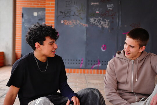 Two teenage boys laughing outside, friendship concept