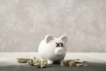 Piggy bank with closed eyes and money on grunge background. Concept of bankruptcy
