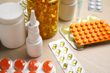 Different pills and bottles of medicines on white wooden background