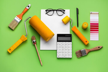 Composition with blank card, calculator and painting tools on green background. Renovation budget...