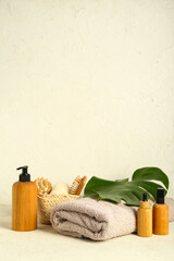 Set of cosmetic products, bath supplies and palm leaf on light background