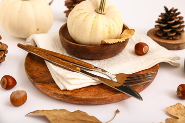Autumn table setting with pumpkins, chestnuts and dried leaves on white background