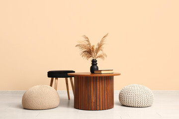 Interior of modern living room with coffee table, chair and poufs