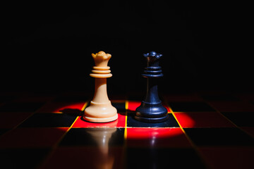 Chess pieces on a red and black board with black background