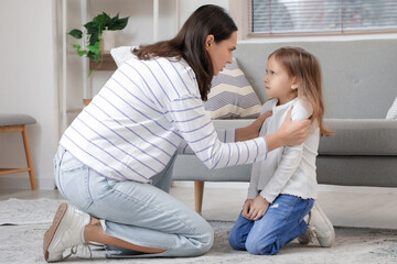 Little girl with her angry mother at home. Domestic violence concept