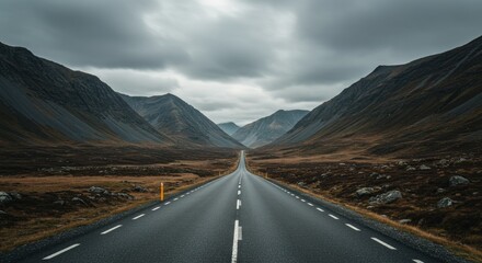 Majestic mountain road leading to the horizon under dramatic skies