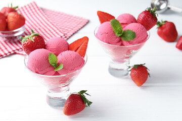 Refreshing sorbet, strawberries and mint in dessert bowls on white wooden table, closeup
