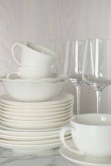 Different clean dishware on white marble table indoors, closeup
