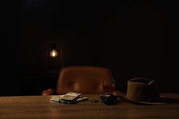 Gun, money, whiskey and other stuff on wooden table in mafia boss office
