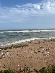 A beach full of trash in the morning. El Malecon, Distrito Nacional, Santo Domingo, Dominican Republic