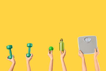 Female hands with sports equipment and weight scales on yellow background