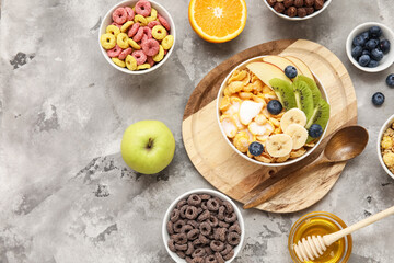 Different healthy cereal bowls with fresh fruits on grey background