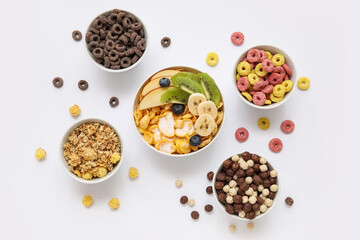 Different healthy cereal bowls with fresh fruits on grey background