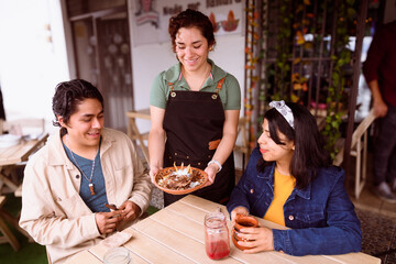 Waitress bringing coffee to a couple in a Mexican restaurant
