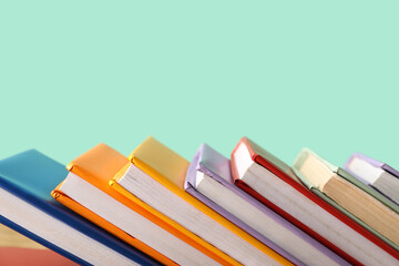 Many colorful books on turquoise background