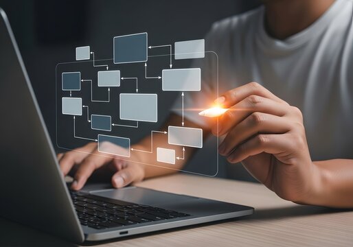 Hand drawing flowchart on laptop screen, indicating workflow, process management. Highlights planning, strategic development. Useful for business presentations, project management.