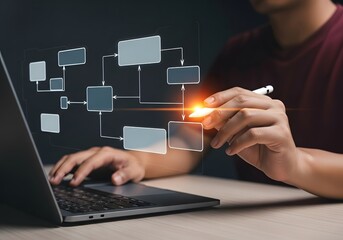 Hand drawing flowchart on laptop screen, indicating workflow, process management. Highlights planning, strategic development. Useful for business presentations, project management.