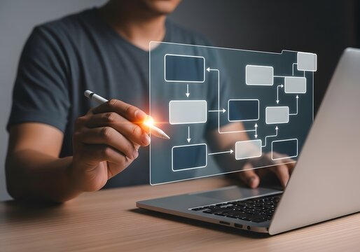 Hand drawing flowchart on laptop screen, indicating workflow, process management. Highlights planning, strategic development. Useful for business presentations, project management.