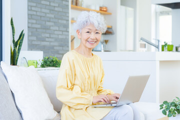 観葉植物に水をやるシニアの女性