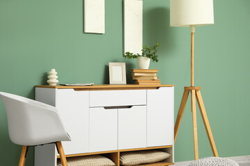 Chest of drawers, armchair and floor lamp in living room, closeup