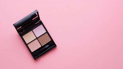 Top view of open eyeshadow palette with four nude shimmer shades on pink background.