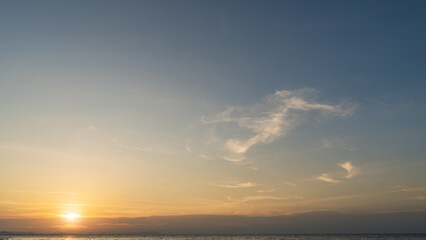 Sunset sky cloud over sea water background in evening with orange, yellow, blue sun light, Horizon sea sunrise sky beautiful landscape nature backgrounds and sun down in golden hour summer, Dusk sky