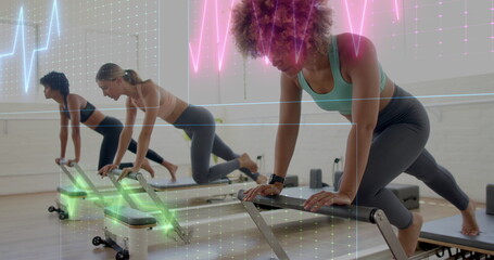 Woman wearing teal sportswear performing pilates workout on reformer in pilates studio, copy space
