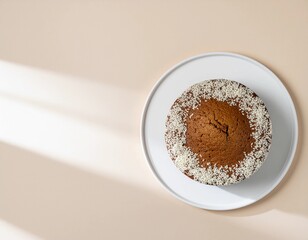 Top view of a round cake with sesame seeds on a white plate, minimal beige background