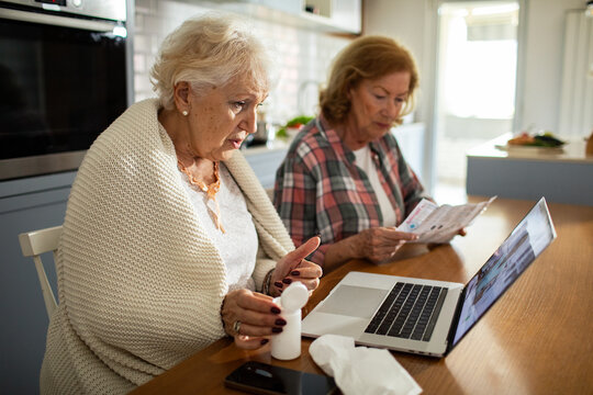 Senior lesbian couple checking medication instructions during online doctor consultation