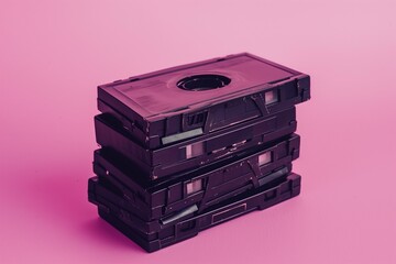 Stack of old VHS tapes on pastel pink background, vintage film concept, retro media layout, nostalgic minimalist flat lay.