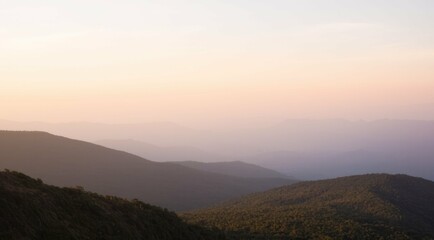 Fototapeta premium Layered mountain range at twilight with soft, pastel light