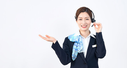 A female staff member wearing a headset giving guidance in front of white background.