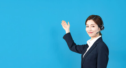 ヘッドセットをつけて説明する女性スタッフ