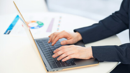 Female business person using a laptop in office.