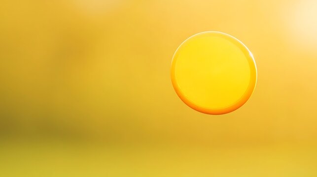 Bright yellow disc floating in a softly blurred golden yellow background