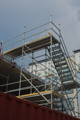 Construction of a Multi-Level Structure Featuring Scaffolding and Safety Measures. View of a modern construction site with scaffolding, concrete structures, and safety precautions, showcasing progress