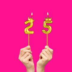 Hands holding number-shaped candles - Birthday number 25